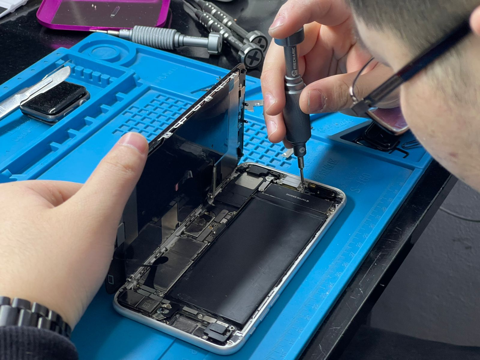 Technician performing iPhone repair in Houston at Klein Wireless Phone Repair
